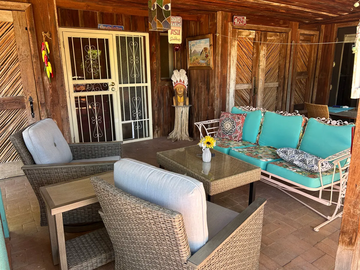 A cozy seating area with decorative wall art and a table adorned with flowers, adjacent to what appears to be large windows or a patio door. The setting suggests an inviting transition from indoors to outdoors, ideal for relaxing after a day of exploration.